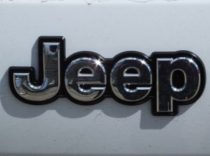 Silver Jeep logo on a white car. - 495 Chrysler Jeep Dodge Ram