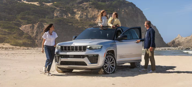 2026 Jeep Grand Cherokee SUV on the beach with family at 495 Chrysler Jeep Dodge Ram
