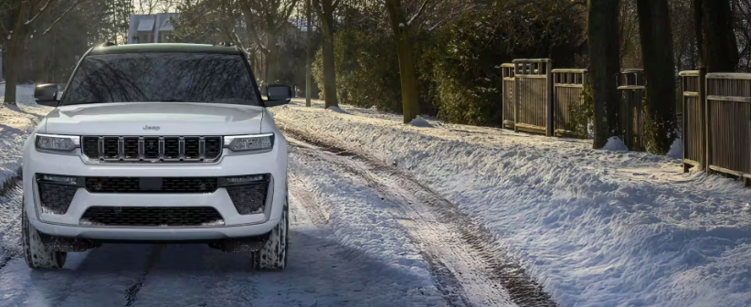 2026 Jeep Grand Cherokee L SUV driving on snowy road in winter
